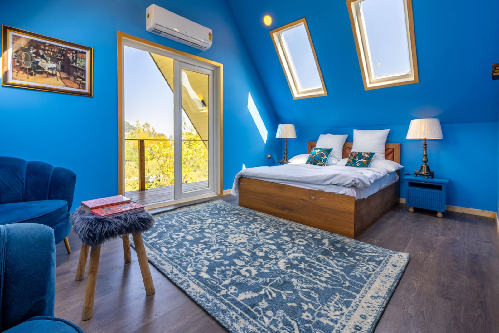 Bright blue bedroom with skylights and warm wood
